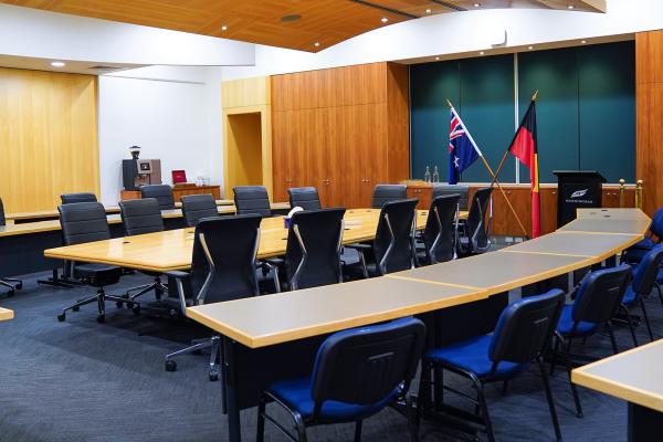 photo inside the council chamber showing the meeting table, the visitor gallery, lectern and both Australian and Aboriginal and Torres Straight Islander flags
