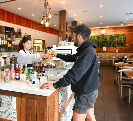 Donburn cafe server giving coffee to customer