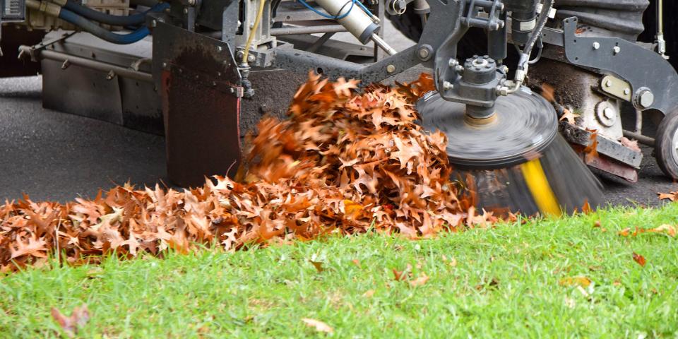 close up of a streetsweeper cleaning gutter