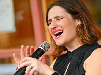 Woman with eyes closed singing into a microphone
