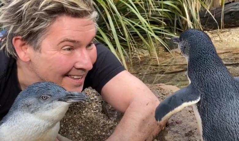 TV Zoologist Chris Humfrey holding a penguin