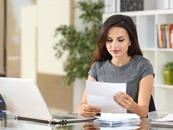 Woman reading letter at desk